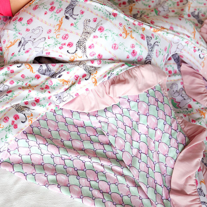 Close-up of a colorful blanket with various patterns including floral and animal designs.