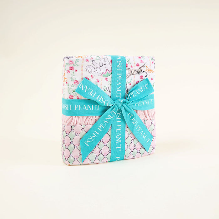 Wrapped blanket with floral pattern and turquoise ribbon on a white background