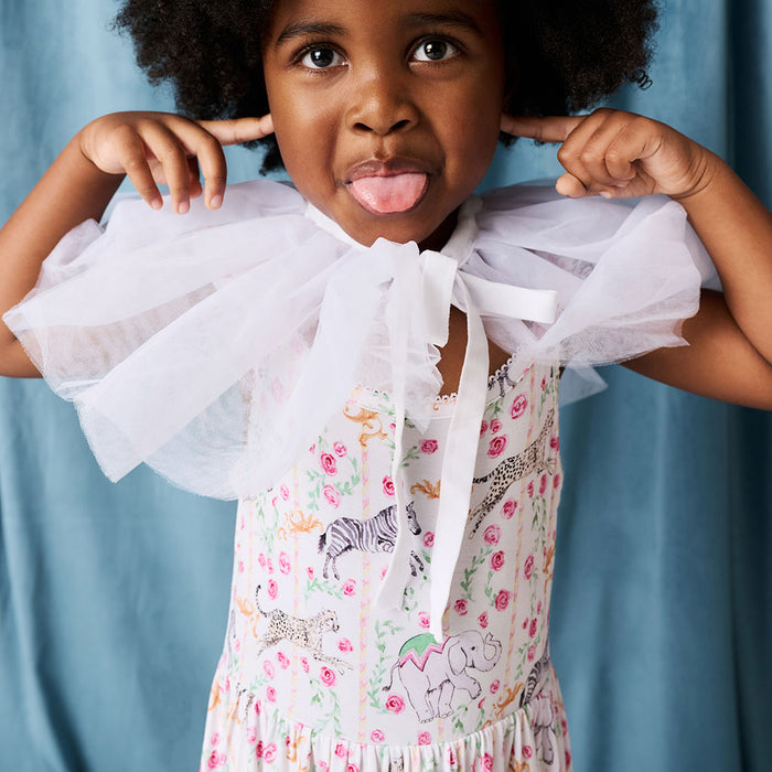 Young girl in a floral dress with a white ruffled collar against a blue background