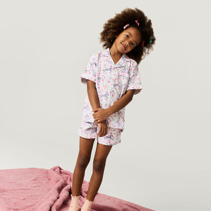 Child wearing a floral pajama set on a plain background