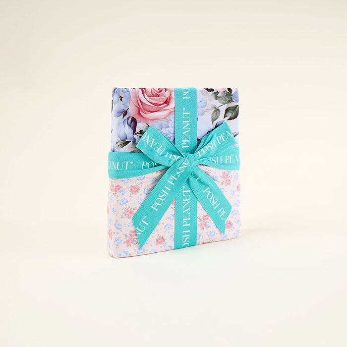 Gift box with floral design and turquoise ribbon on a light background