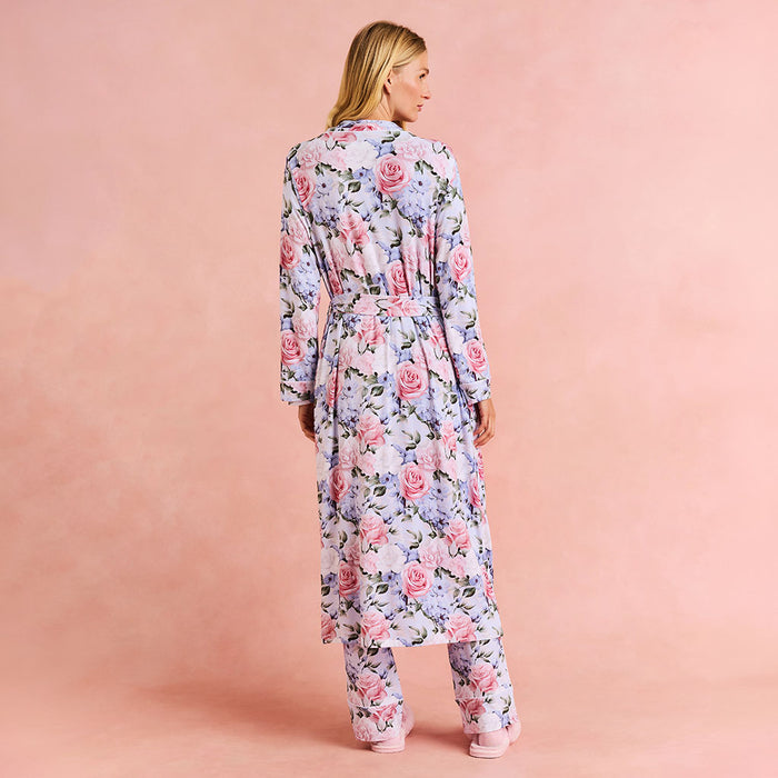 Back image of woman wearing a floral robe and pajama set on a pink background