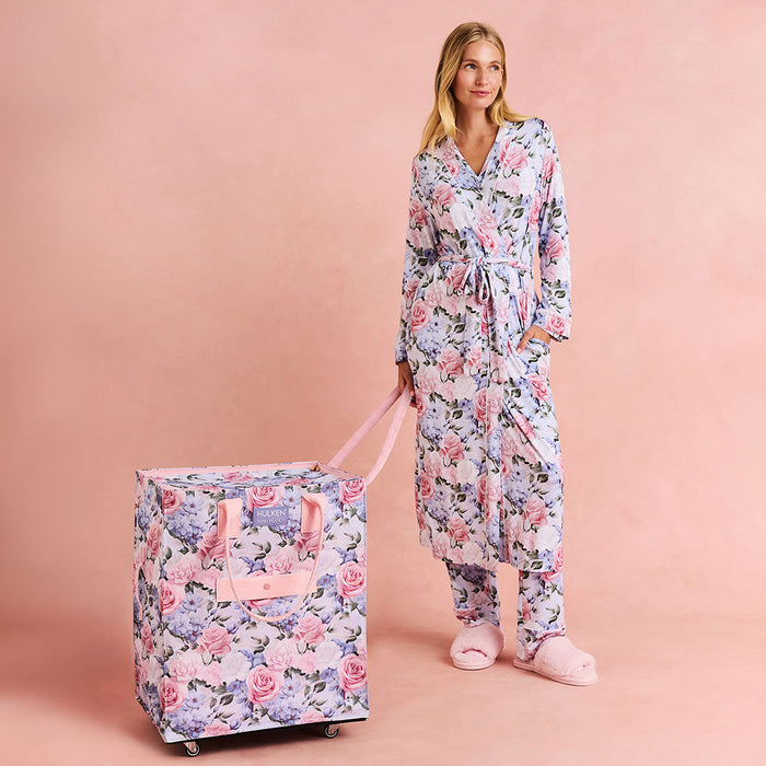Woman in floral pajama set with matching large Hulken tote bag on a pink background