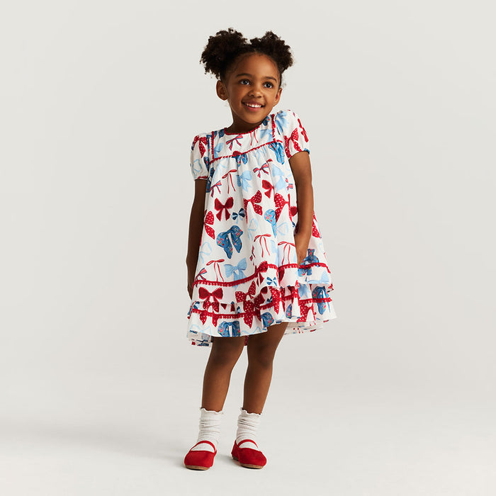 Young girl wearing a colorful dress with a white background