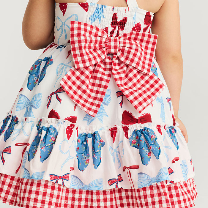 Dress with a large red and white checkered bow and butterfly pattern on a plain background