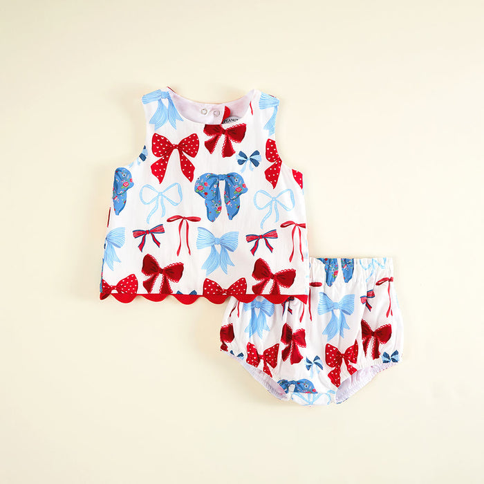 Children's sleeveless top and bloomers set with red and blue bow pattern on a beige background