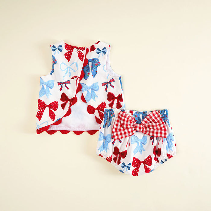 Children's outfit with a top and bloomers featuring red, white, and blue bow patterns on a beige background.