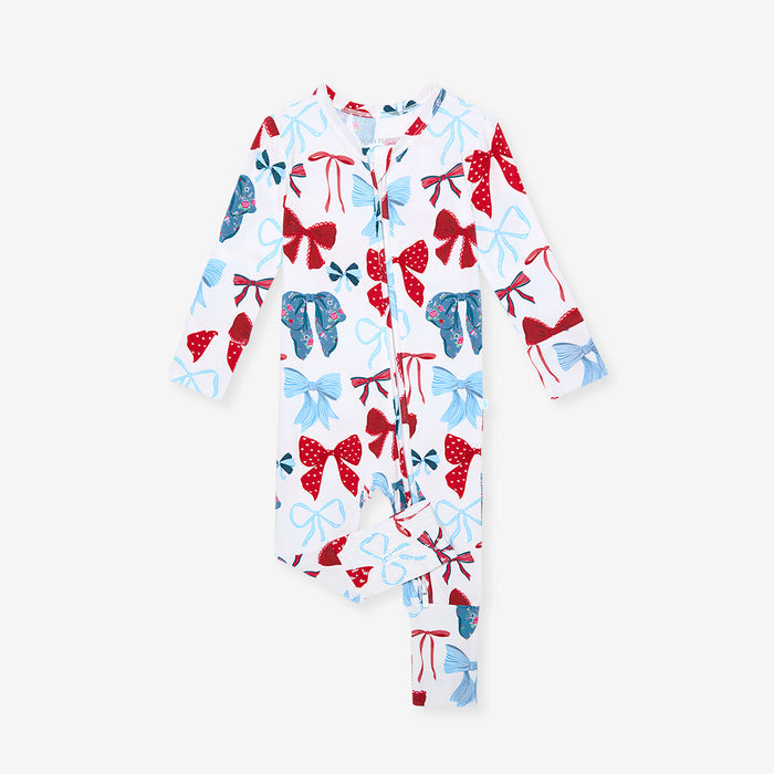 Children's onesie with red, blue, and white bow pattern on a white background