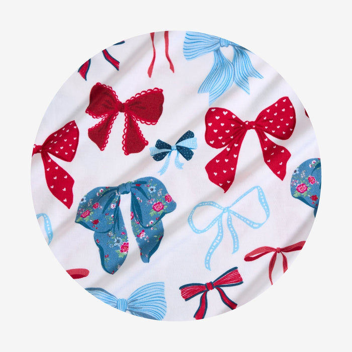 Round fabric headband with colorful bow pattern on a white background