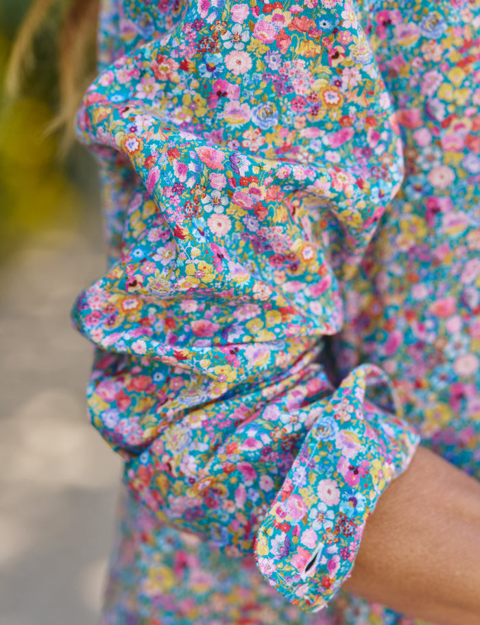 Close-up of a colorful floral dress with ruffled sleeves.