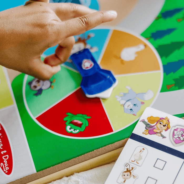 little girls hand spins the wheel on the activity board