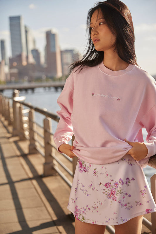 light pink Crewneck pullover sweater with embroidered flowers near the neckline and LSF logo at the sleeve cuff