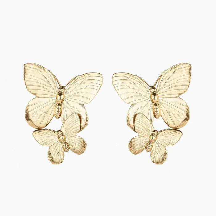 Explore our Papillon Earring - Gold, wearable art featuring intricately crafted butterflies, with a larger one elegantly perched on top and a smaller one beneath. These popular gold pieces stand out against a white background, blending sophistication with playful charm.