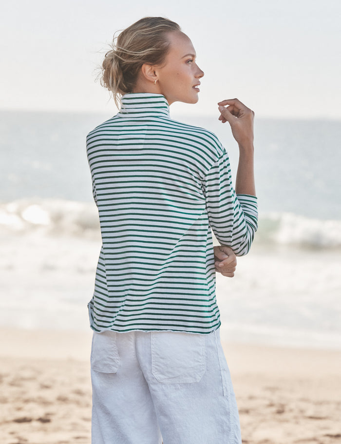 Woman wearing a striped shirt and white pants on a beach