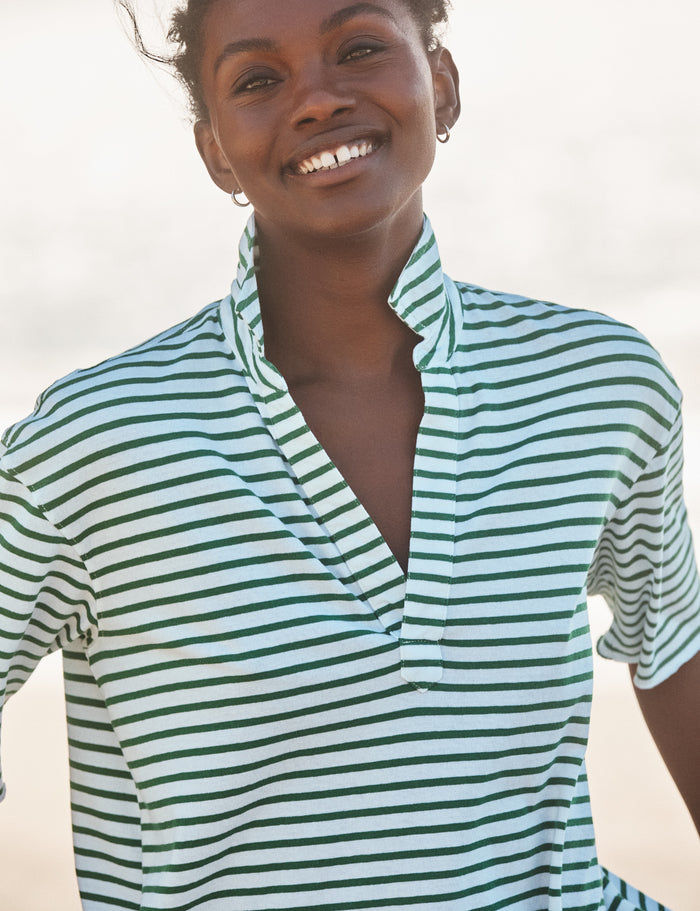 Woman wearing a green and white striped shirt against a neutral background