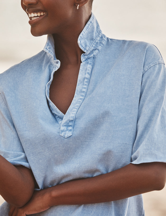 Woman wearing a light blue shirt with a neutral background