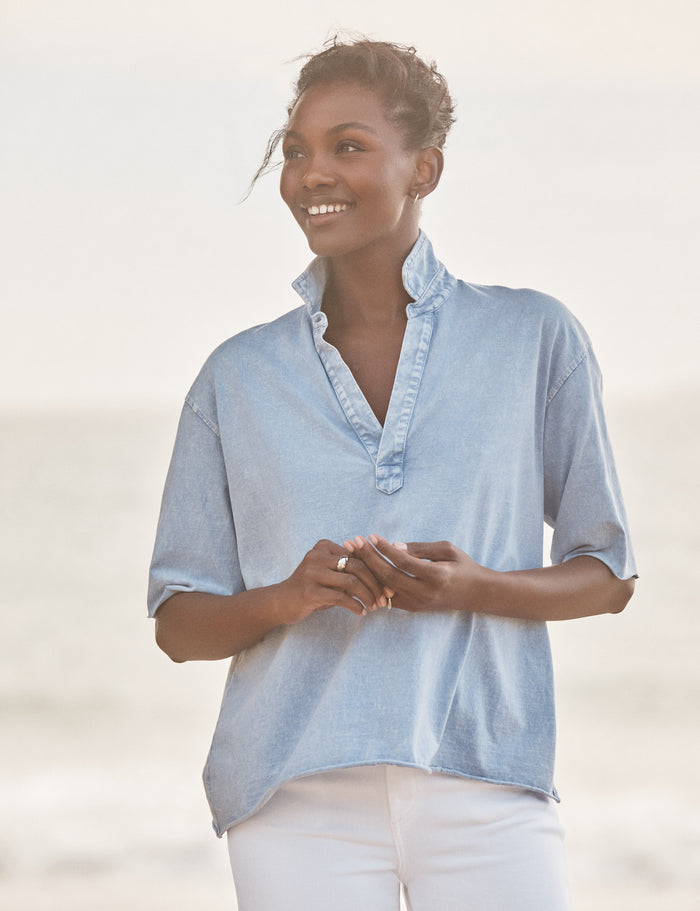 Woman wearing a light blue shirt with a blurred background