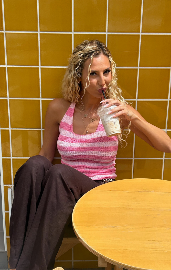 Woman drinking from a cup in a tiled room