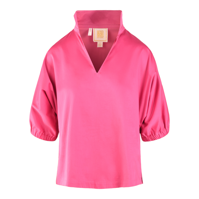The Poppy Top is a bright pink, loose-fitting cotton poplin blouse with a high collar, deep V-neckline, and elbow-length puff sleeves gathered with elastic at the cuffs.