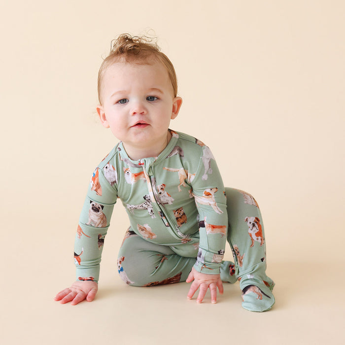 child crawling wearing a green dog printed one piece