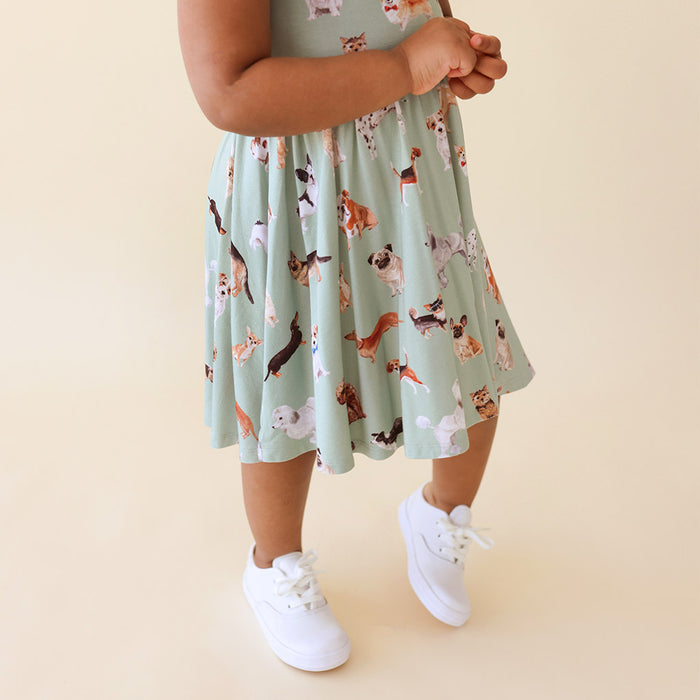 close up of child wearing a green dress with dog patterned print