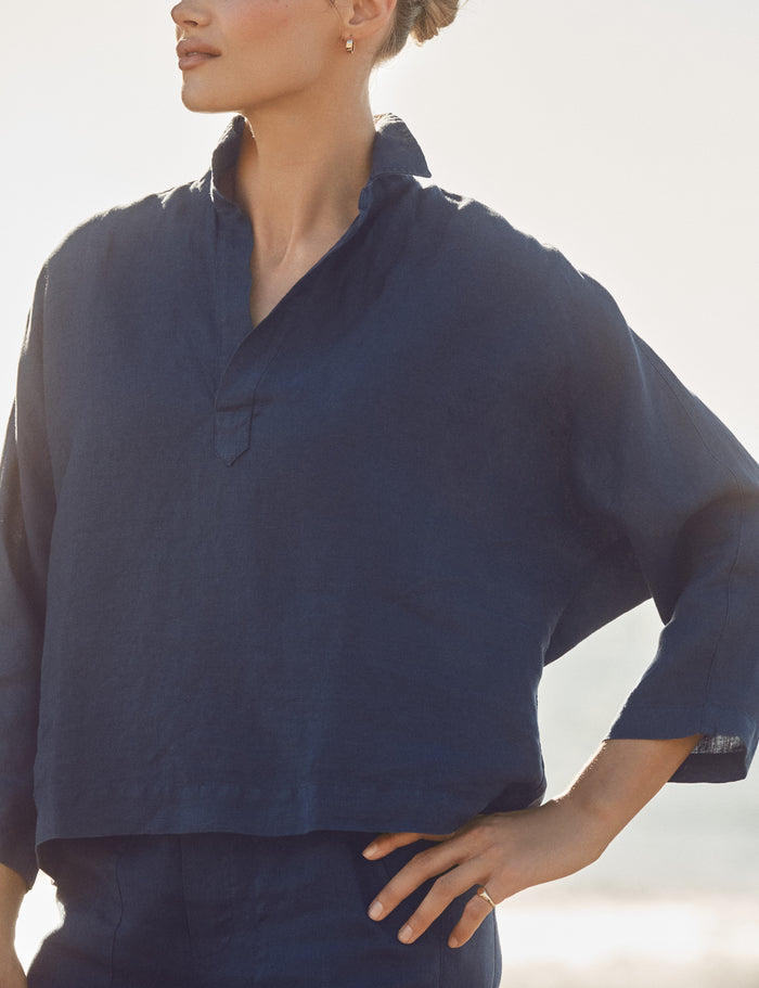 Person wearing a navy blue shirt with a blurred background