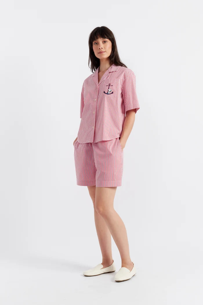 Woman wearing a pink outfit with an anchor design on a white background