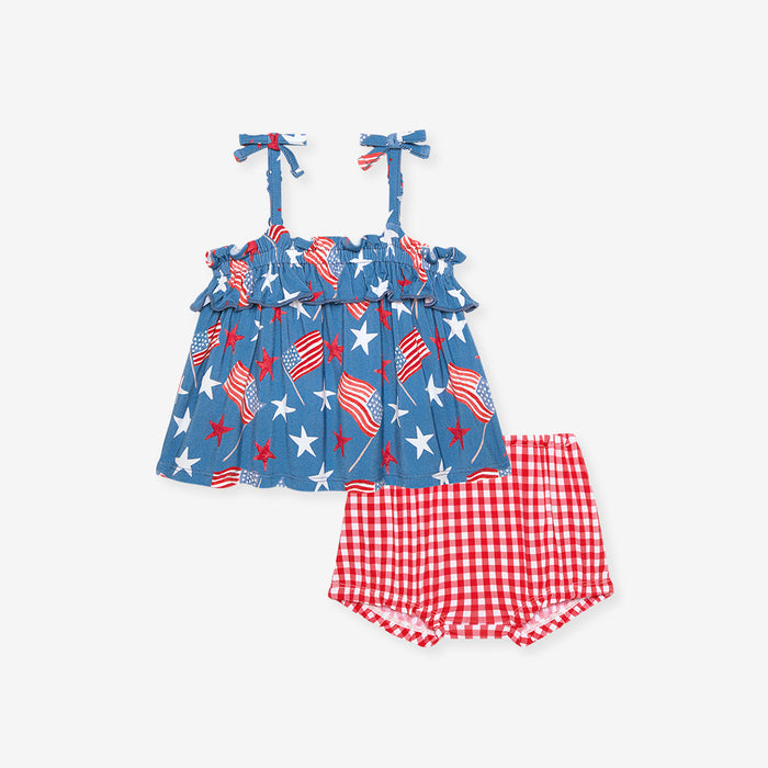 Children's outfit with blue top and red checkered shorts on a white background