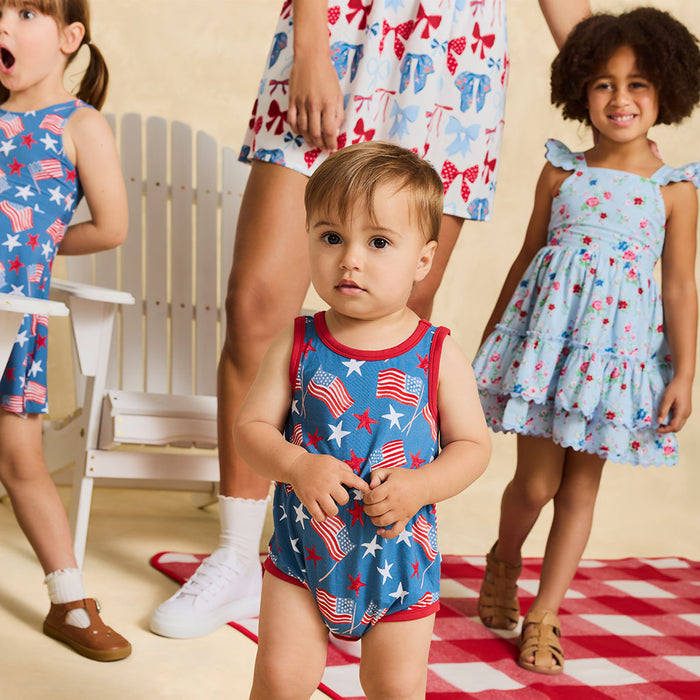 Children wearing patriotic-themed clothing on a checkered floor.
