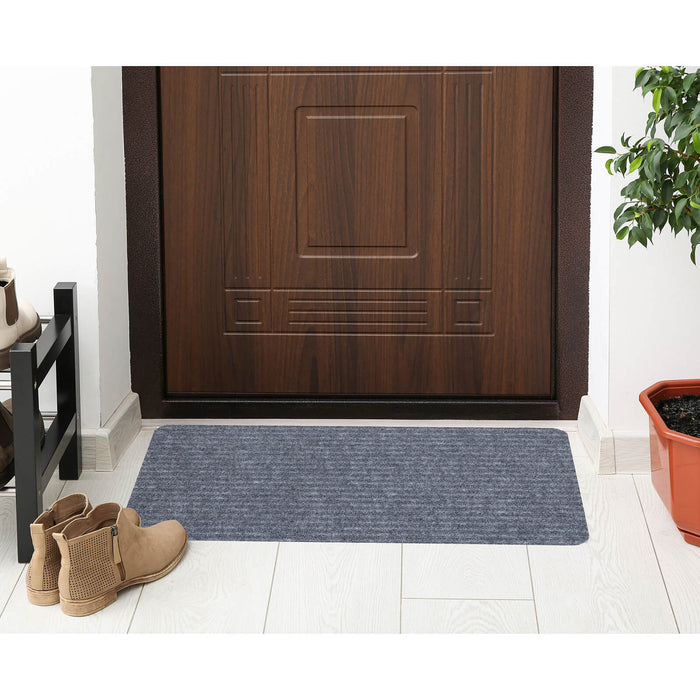 Grey ridged door mat on the floor with plant and boots