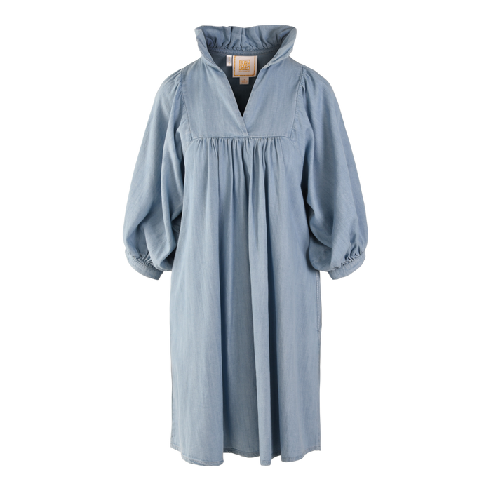 The Stella Midi, made of denim chambray, features long puffy sleeves and a loose, gathered silhouette. It has a ruffle stand collar with a v-neck opening, all showcased on a plain white background.