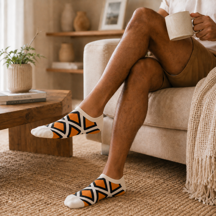 White, Orange and Black patterned low-cut socks worn in a relaxed lifestyle setting.