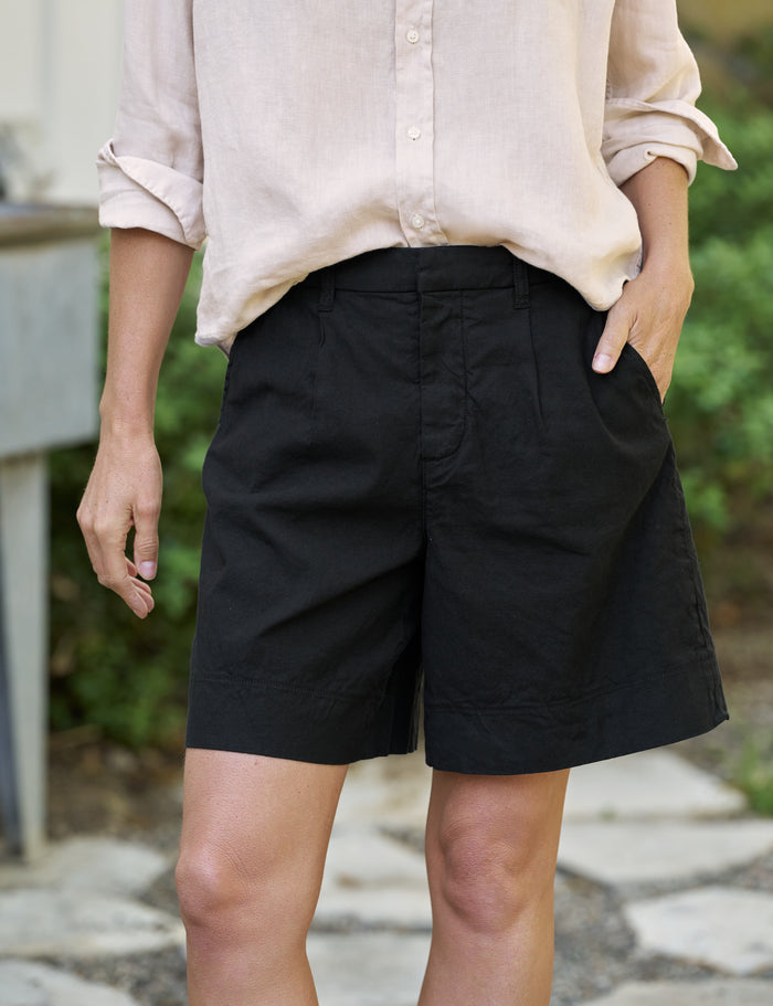 Person wearing black shorts and a light-colored shirt outdoors